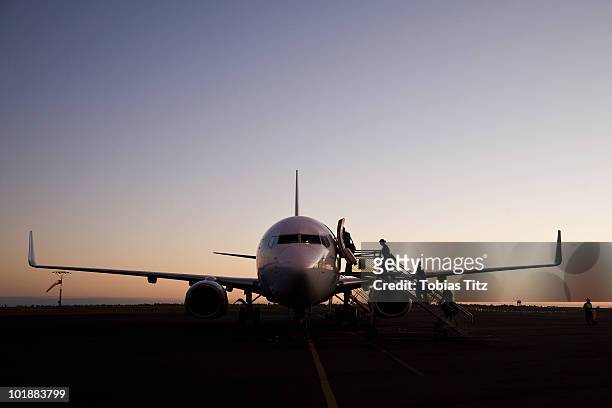 people boarding an airplane at dusk,  port hedland, western australia, australia - western australia fotografías e imágenes de stock
