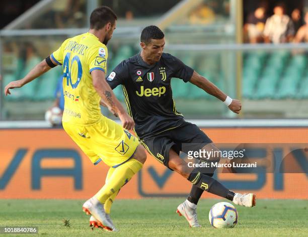 Cristiano Ronaldo of Juventus FC is challenged by Nenad Tomovic of Chievo Verona during the serie A match between Chievo Verona and Juventus at...