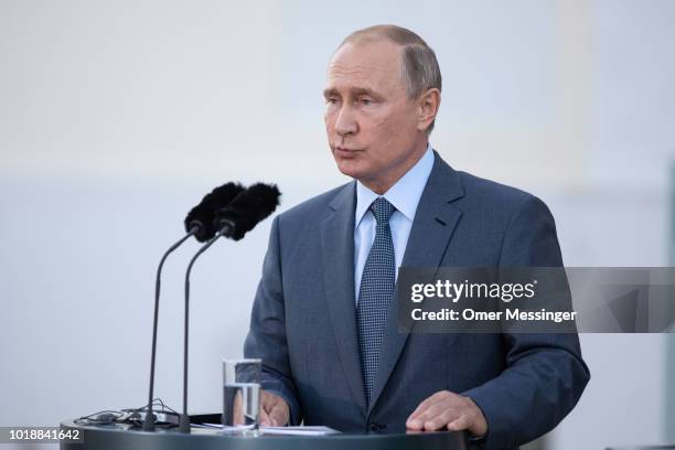 Russian President Vladimir Putin speaks during a joint press statement with German Chancellor Angela Merkel prior to their meeting at Schloss...