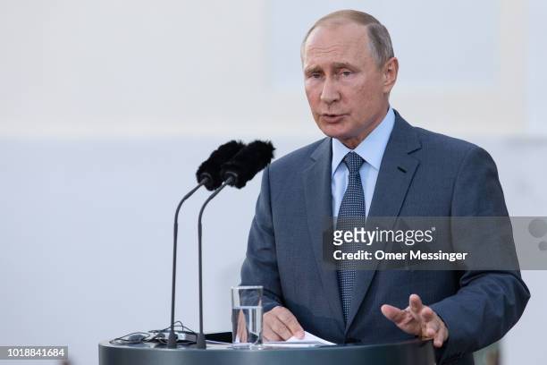Russian President Vladimir Putin speaks during a joint press statement with German Chancellor Angela Merkel prior to their meeting at Schloss...