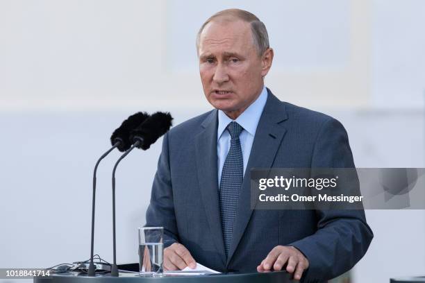 Russian President Vladimir Putin speaks during a joint press statement with German Chancellor Angela Merkel prior to their meeting at Schloss...