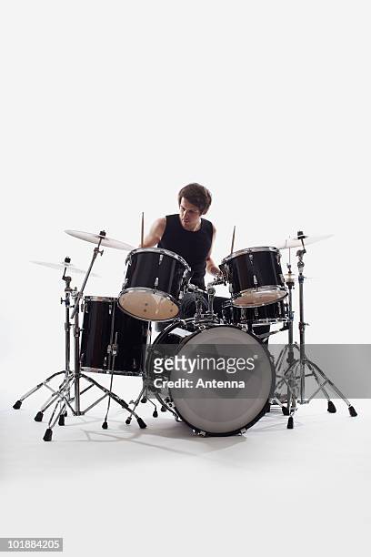 a man on drums performing, studio shot, white background, back lit - drums white background stock pictures, royalty-free photos & images