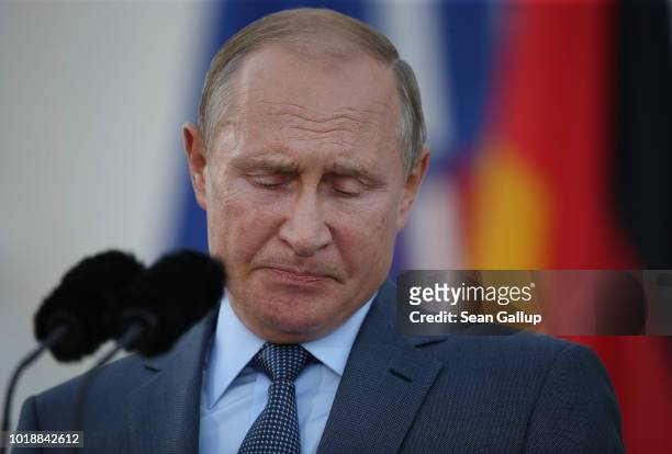 Russian President Vladimir Putin and German Chancellor Angela Merkel give statements to the media prior to talks at Schloss Meseberg palace, the...