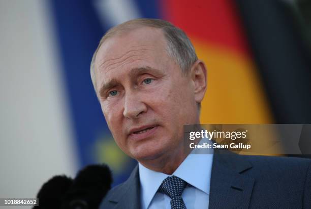 Russian President Vladimir Putin and German Chancellor Angela Merkel give statements to the media prior to talks at Schloss Meseberg palace, the...