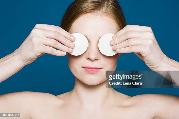 a woman with two cotton pads held up over her eyes - cotton pad stock pictures, royalty-free photos & images