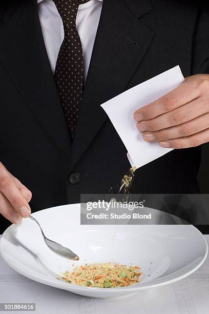 A Man Pouring Instant Soup Powder Into A Bowl, Foto de stock
