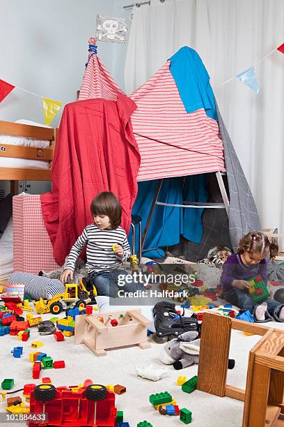 a young boy and girl playing in a bedroom - niño en la sala con juguetes fotografías e imágenes de stock