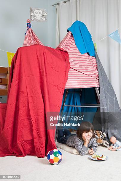 a young boy in a fort having a snack - kids fort imagens e fotografias de stock