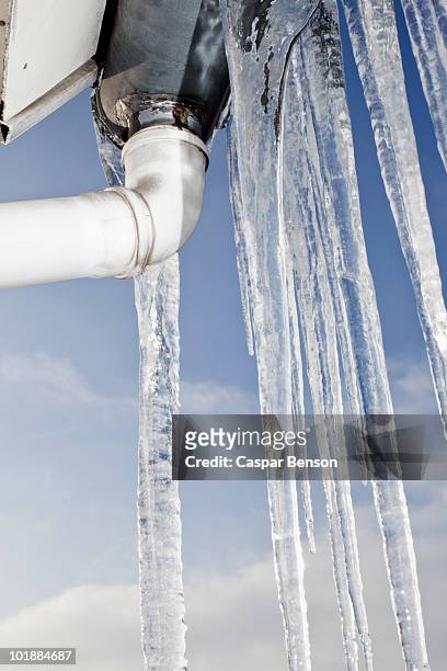detail of icicles hanging from a roof - frozen pipes foto e immagini stock