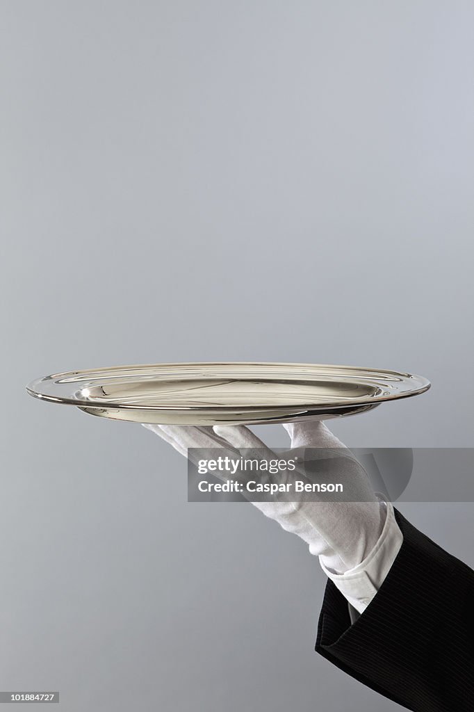 Detail of a butler holding a sliver platter
