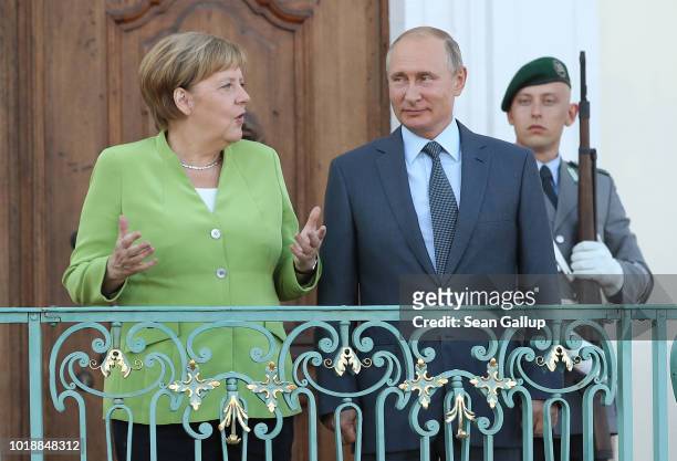 German Chancellor Angela Merkel and Russian President Vladimir Putin chat upon his arrival at Schloss Meseberg palace, the German government retreat,...