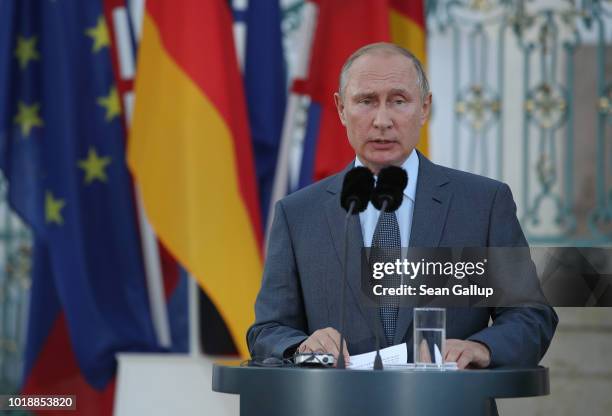 Russian President Vladimir Putin and German Chancellor Angela Merkel give statements to the media prior to talks at Schloss Meseberg palace, the...