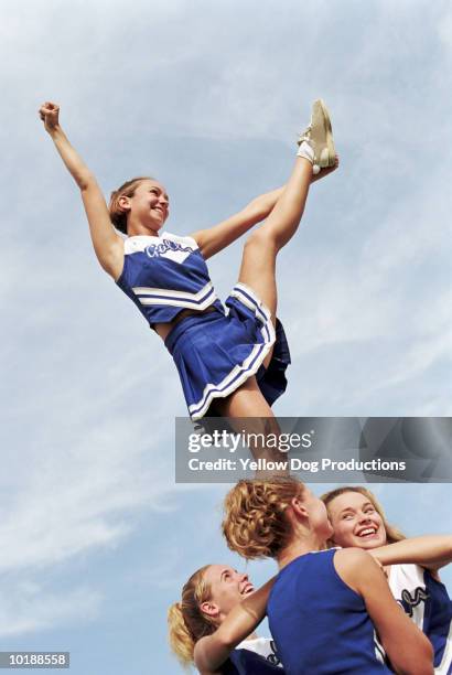 cheerleader with leg raised on pyramid - cheerleading stock-fotos und bilder