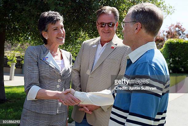 Republican candidate for U.S. Senate and former HP CEO Carly Fiorina and her husband Frank Fiorina greet a voter outside of a polling place June 8,...