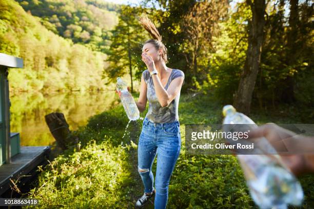 young woman splashing water over her face - women in wet tee shirts stock pictures, royalty-free photos & images