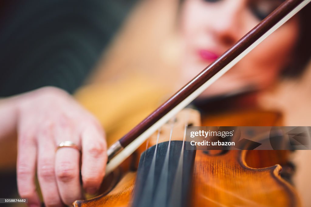 Beautiful woman artist playing the violin on the stage.