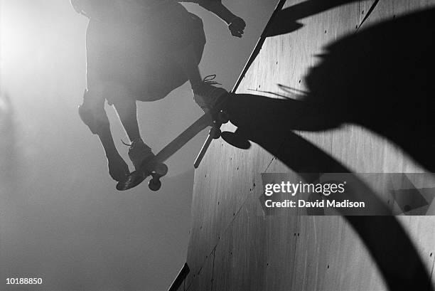 skateboarder doing stunts on halfpipe, low angle view (b&w) - active silhouettes stock pictures, royalty-free photos & images