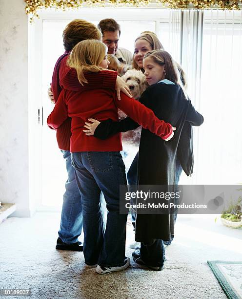 family hugging in living room - fyrbarnsfamilj bildbanksfoton och bilder