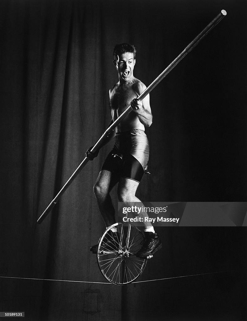 Male unicyclist on tightrope (B&W)
