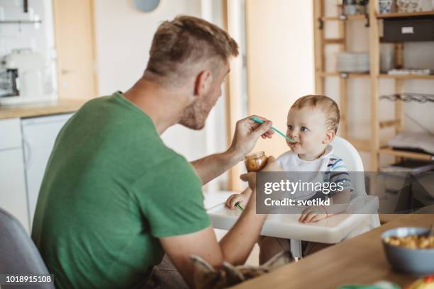 je moet eten om grote en sterke - baby feeding stockfoto's en -beelden