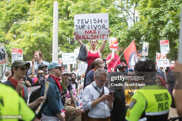 Counter-protesters hold up signs during a rally organized by Boston Free Speech at City Hall Plaza on August 18, 2018 in Boston, Massachusetts.