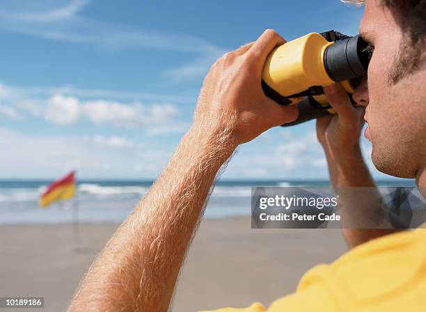 lifeguard keeping watch on beach - lifeguard fotografías e imágenes de stock