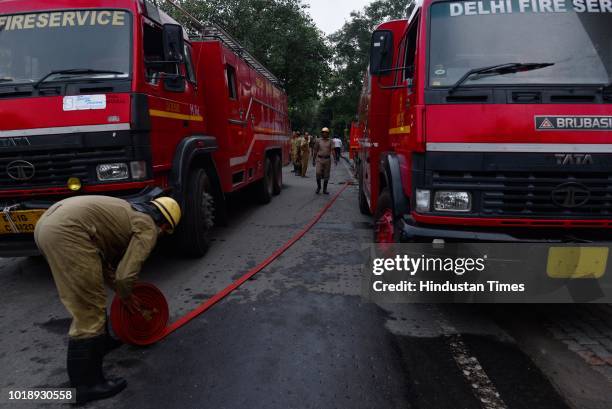 Firefighters folding the hoze pipe after dozing a fire inside the office of Enforcement Directorate on sixth floor at Lok Nayak Bhawan, Khan Market...