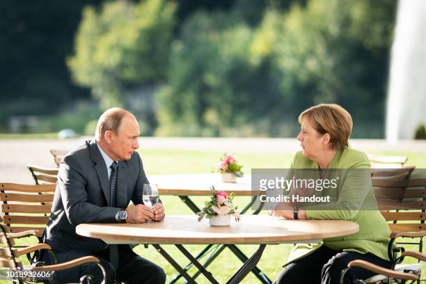 In this handout photo provided by the German Government Press Office , German Chancellor Angela Merkel and Russian President Vladimir Putin meet at...