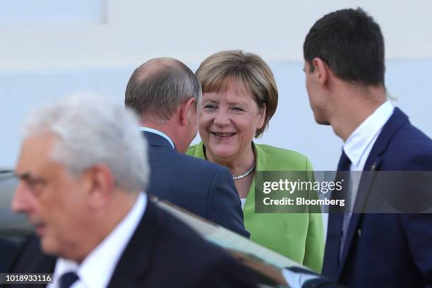 Angela Merkel, Germany's chancellor, center, greets Vladimir Putin, Russia's president, during a bilateral meeting at Schloss Meseberg castle in...