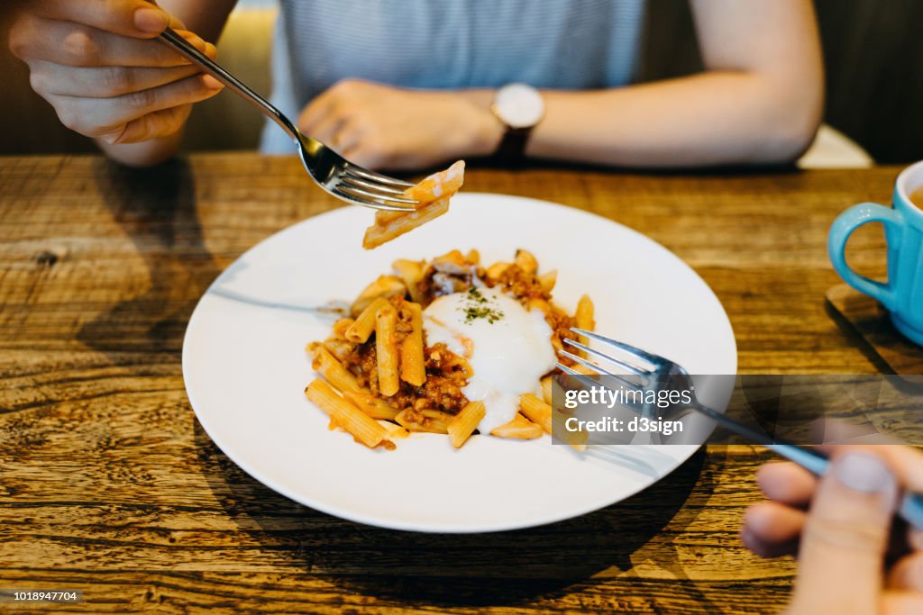 Girlfriend and boyfriend sharing pasta on lunch in a restaurant