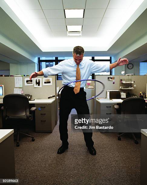 businessman in open plan office playing with plastic hoop - hoelahoep stockfoto's en -beelden