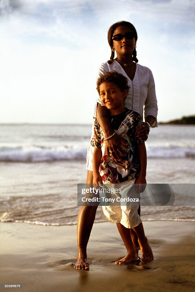 Mother and son (9-11 years) standing on beach, portrait