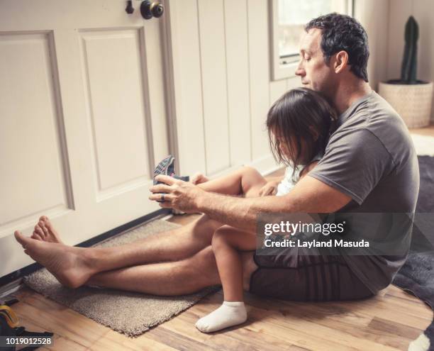 father putting shoes on toddler daughter - girl dressing up stock pictures, royalty-free photos & images