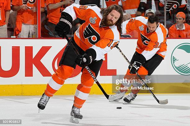 Scott Hartnell of the Philadelphia Flyers handles the puck followed by teammate Riley Cote against the Chicago Blackhawks in Game Four of the 2010...