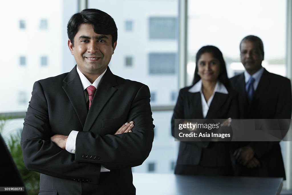 Indian business man standing in front of colleagues