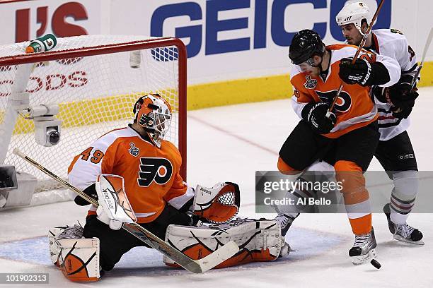 Matt Carle of the Philadelphia Flyers fights for the puck against Dave Bolland of the Chicago Blackhawks in front of the net of Michael Leighton of...