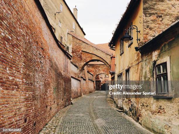 old narrow street in historic center of sibiu, transylvania, romania - romania village stock pictures, royalty-free photos & images