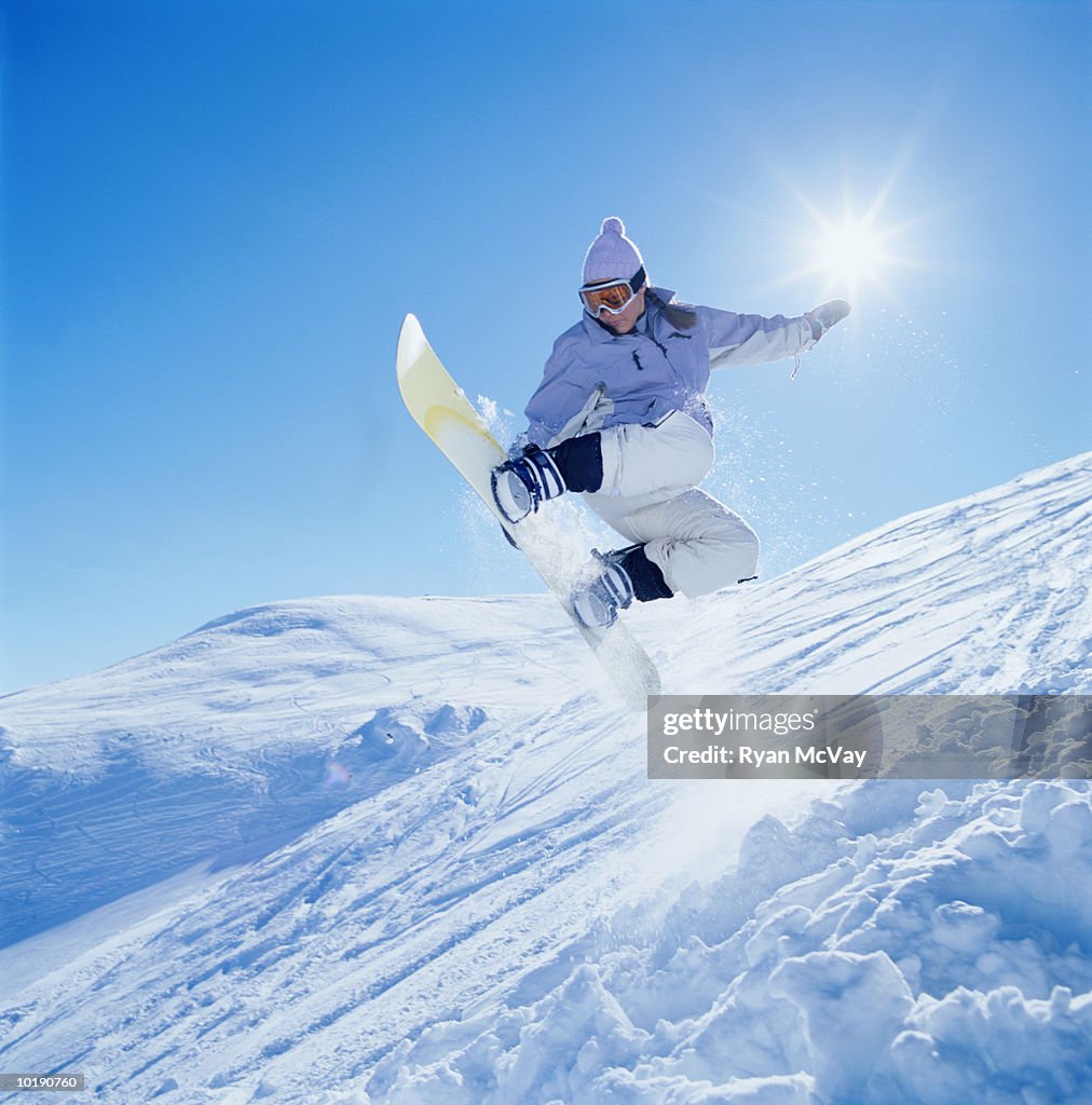 Girl (15-17) snowboarding, low angle view, Sun Valley Idaho, USA