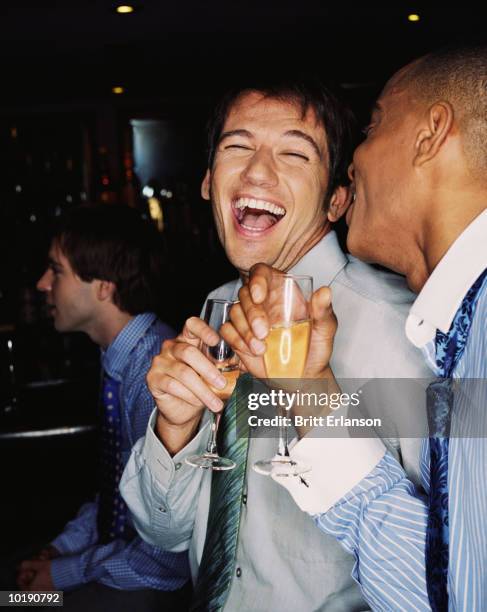 three businessmen at bar drinking and laughing - office party imagens e fotografias de stock