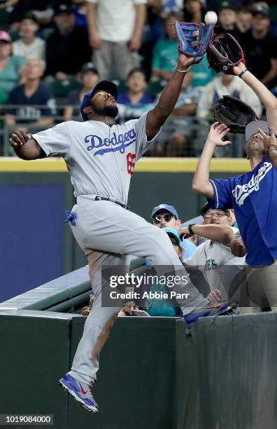 Yasiel Puig of the Los Angeles Dodgers reaches for what would be a missed fly out attempt off a hit by Mitch Haniger of the Seattle Mariners in the...