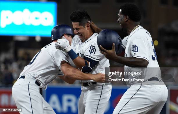 Christian Villanueva of the San Diego Padres celebrates his walk off single with Franmil Reyes and Hunter Renfroe during the ninth inning of a...