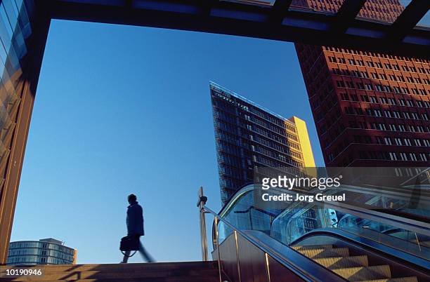 businessman leaving railway station (digital enhancement) - potsdamer platz photos et images de collection