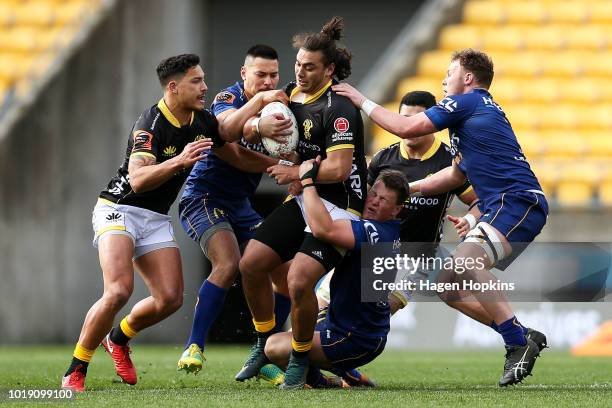 Peter Umaga-Jensen of Wellington is tackled by Finn Strawbridge and Sio Tomkinson of Otago during the round one Mitre 10 Cup match between Wellington...