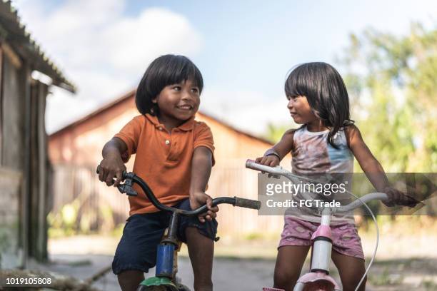 siblings riding a bicycle in a rural place - brazilian culture stock pictures, royalty-free photos & images