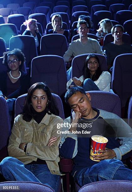 bored couple in movie theater, man asleep - romance film stock-fotos und bilder