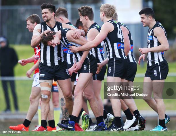 Tyler Brown of the Magpies celebrates a goal with teammates during the round 20 VFL match between Collingwood and Frankston at Victoria Park on...