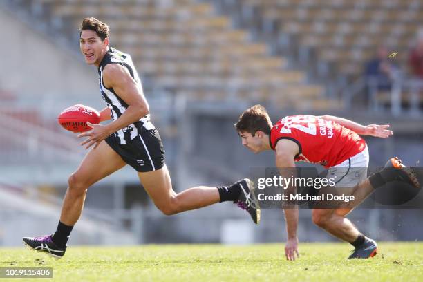 Stephen Tahana of the Magpies runs with the ball from Lachlan Gill-Renouf during the round 20 VFL match between Collingwood and Frankston at Victoria...