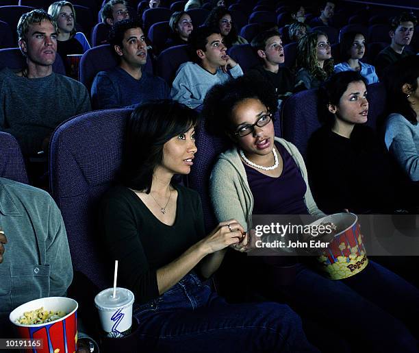 two women talking during movie in theater - biosalong bildbanksfoton och bilder