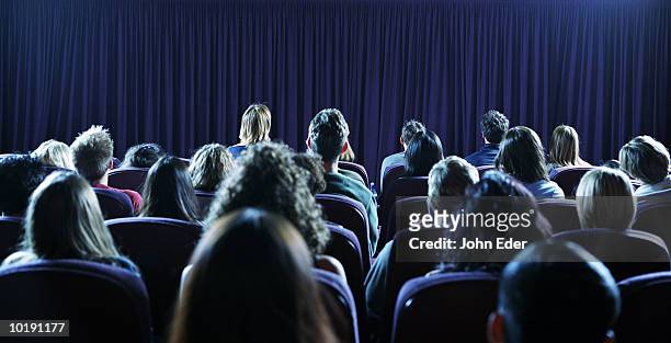crowd of people in movie theater, rear view - movie theatre audience stock-fotos und bilder