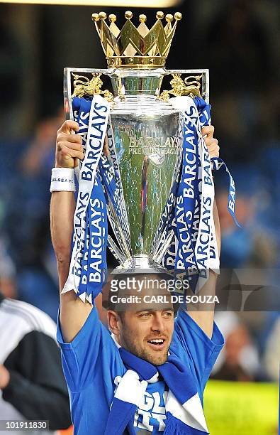 Chelsea's English midfielder Joe Cole celebrates with the Barclays Premier league trophy after Chelsea win the title with a 8-0 victory over Wigan...